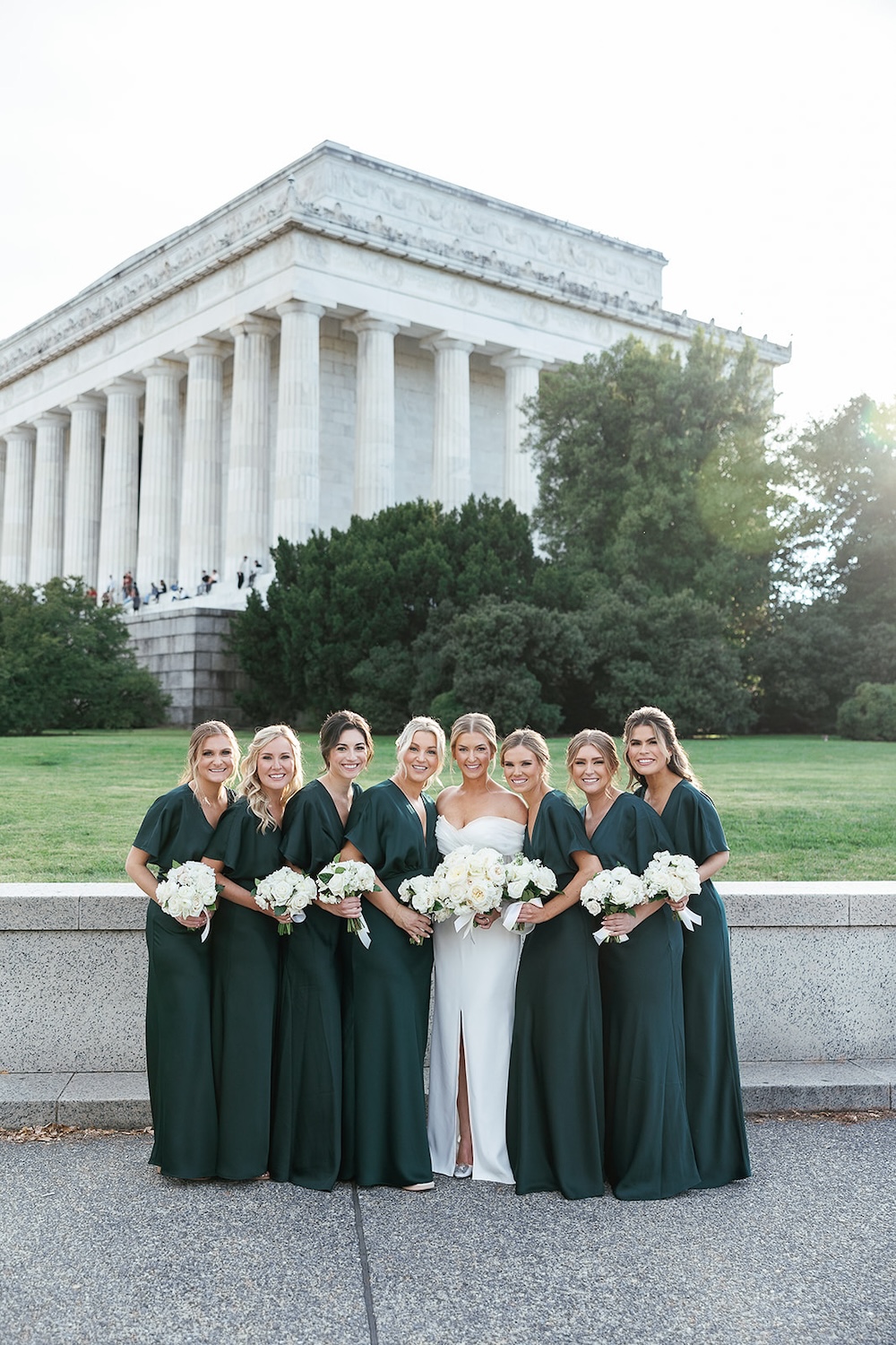 bridal party portrait at Lincoln Memorial. Long emerald green bridesmaids dresses, white bouquets. High end hotel ballroom wedding, The Fairmont, Washington DC. Sarah Bradshaw Photography