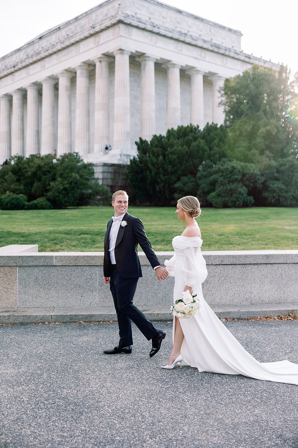 portrait of bride and groom walking in front of Lincoln Memorial. High end hotel ballroom wedding, The Fairmont, Washington DC. Sarah Bradshaw Photography