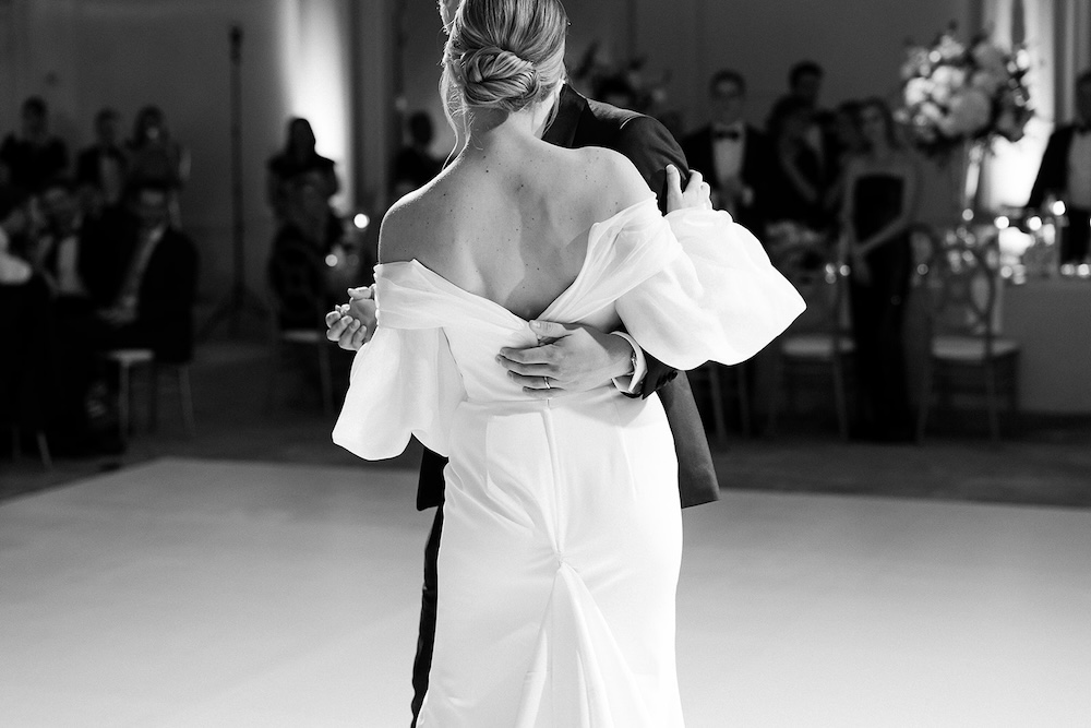 black and white portrait of wedding first dance. open back wedding dress, off shoulders long sleeves. High end hotel ballroom wedding, The Fairmont, Washington DC. Sarah Bradshaw Photography